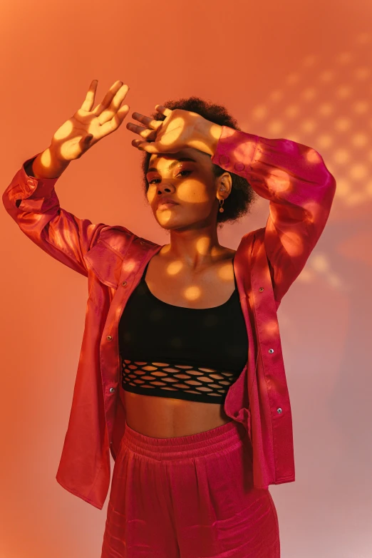 a woman in a black top and pink pants, trending on pexels, holography, red jacket, warm lighting with cool shadows, sport bra and shirt, young black woman