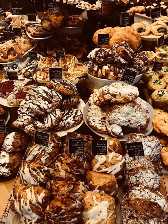 a display case filled with lots of different types of pastries, a photo, pexels, renaissance, made of glazed, winter, black, italian