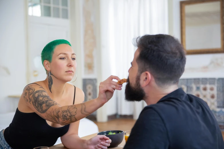 a man feeding a woman a bowl of food, inspired by Elsa Bleda, pexels contest winner, hyperrealism, short unkempt green hair, avatar image, tattooed face, androgynous male