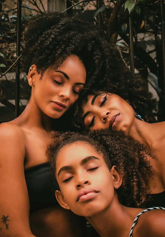 a couple of women laying on top of each other, by Niko Henrichon, pexels contest winner, afrofuturism, portrait of family of three, curly middle part haircut, instagram post, brazilian