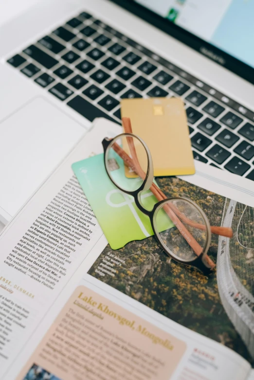 an open laptop computer sitting on top of a desk, by Carey Morris, trending on unsplash, figuration libre, square glasses, focus on card, print magazine quality, lime and gold hue