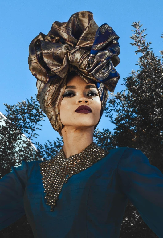 a woman in a blue dress and a large hat, an album cover, pexels contest winner, afrofuturism, baroque gold headpiece, moroccan queens ny, outdoor photo, “zendaya