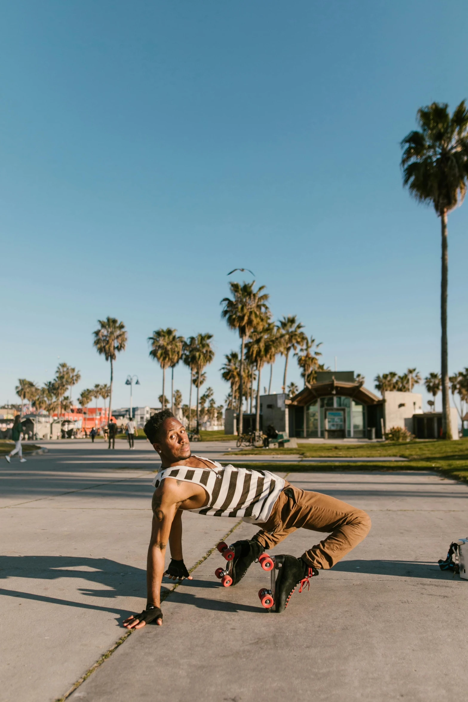 a man riding a skateboard down a sidewalk, by Julia Pishtar, happening, palm trees on the beach, doing splits and stretching, ashteroth, smiling playfully