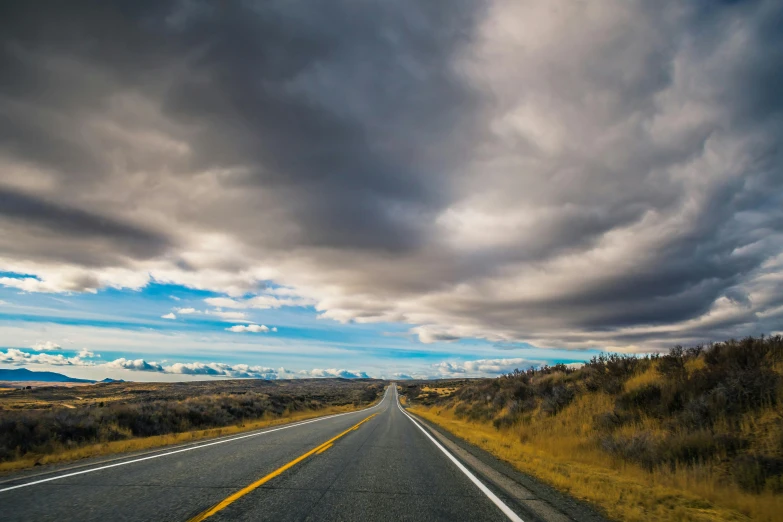 an empty road in the middle of nowhere, unsplash, realism, thunderclouds, corduroy road, tourist photo