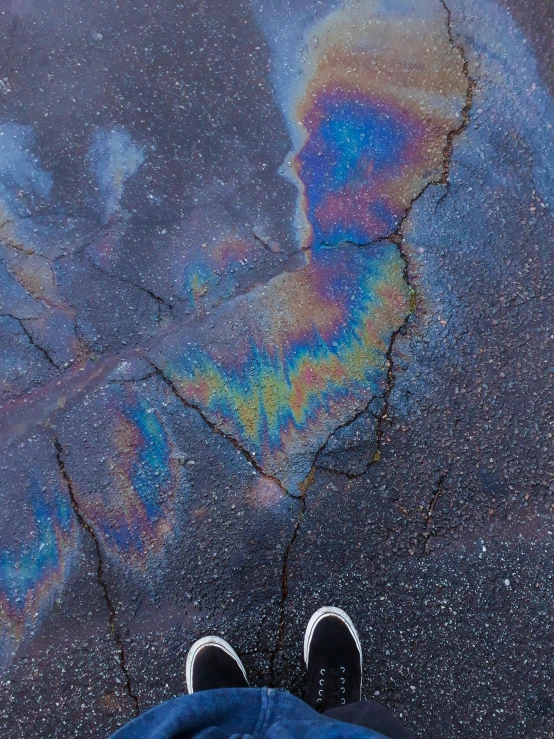 a person standing in front of a puddle of oil, trending on unsplash, 🚀🌈🤩, sneaker photo, glassy fracture, /r/earthporn