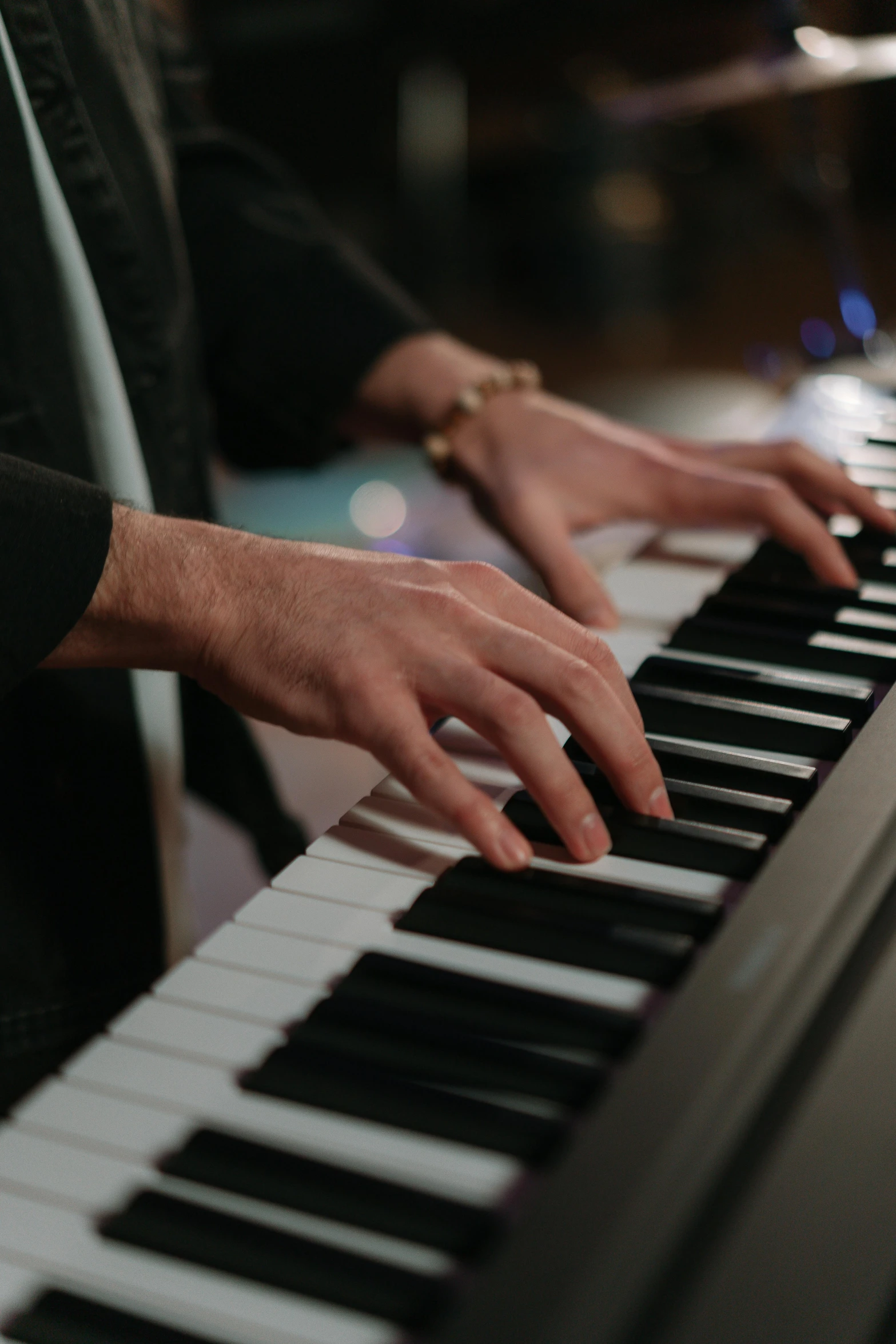 a close up of a person playing a piano, in the evening