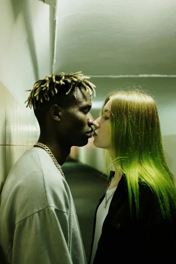 a man and a woman standing next to each other, an album cover, inspired by Elsa Bleda, trending on pexels, bright green hair, adut akech, lesbian kiss, xxxtentacion