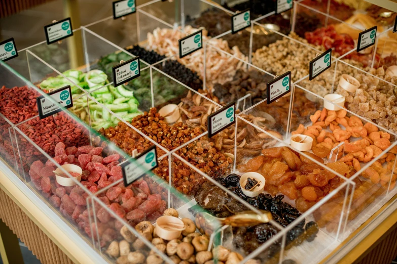 a display case filled with lots of different kinds of nuts, trending on pexels, hurufiyya, with sparkling gems on top, basil gogos, facing away, fruit