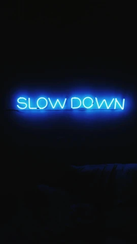 a neon sign that says slow down in the dark, an album cover, by Bruce Nauman, unsplash, ffffound, yung lean, geoff darrow, blue
