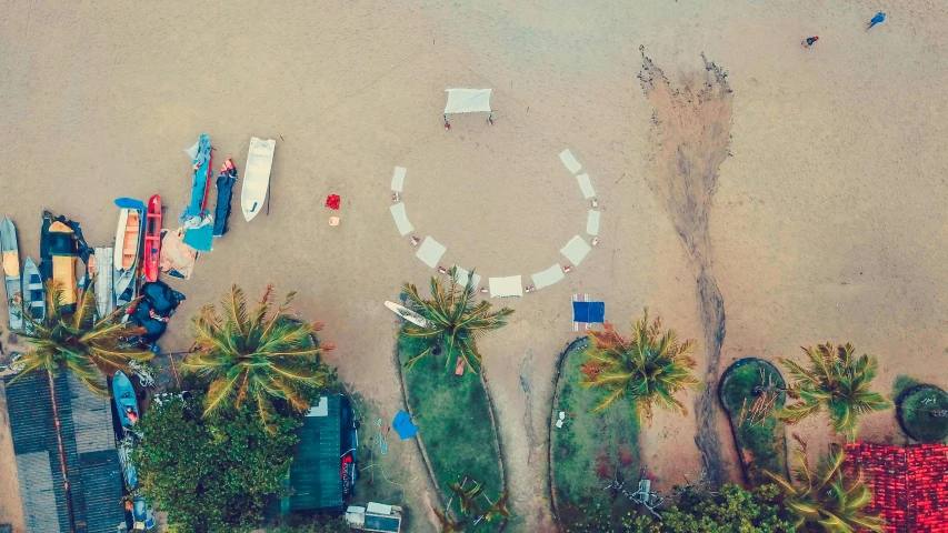 a group of surfboards sitting on top of a sandy beach, pexels contest winner, land art, top view of convertible, everything enclosed in a circle, beach bar, palm trees on the beach