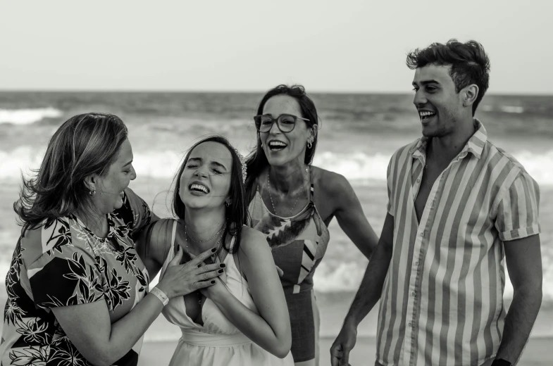 a group of people standing next to each other on a beach, a black and white photo, pexels contest winner, earing a shirt laughing, photoshoot for skincare brand, many partygoers, casual game