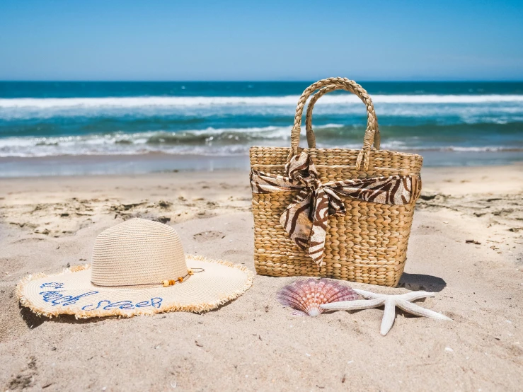 a straw bag sitting on top of a sandy beach, on the ocean, at the sea, profile image, day time