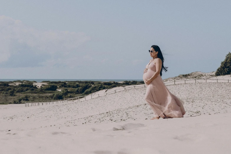 a pregnant woman is walking on the beach, by Daniel Lieske, pexels contest winner, dune style, handsome girl, birth, video