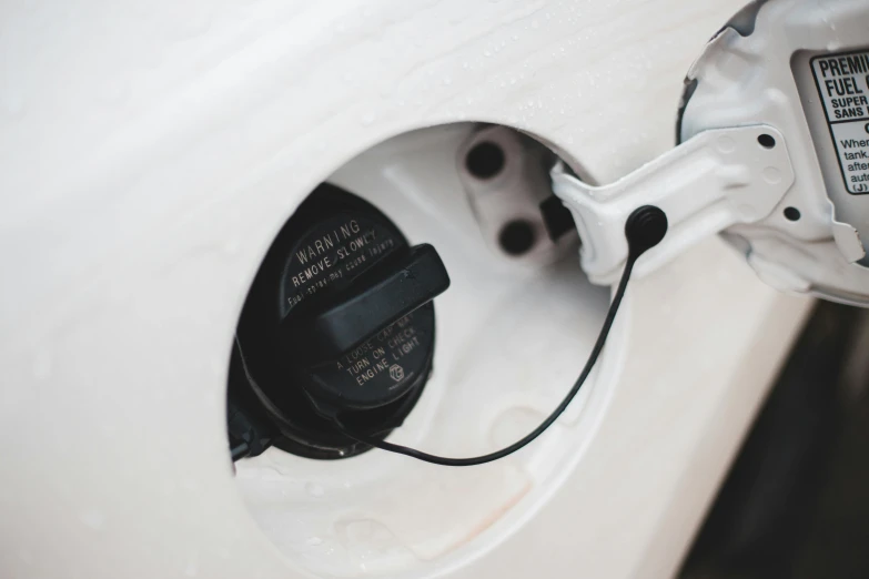 an electric charger plugged into a white car, by Thomas Häfner, pexels contest winner, intricate oil details, top lid, 4l, back