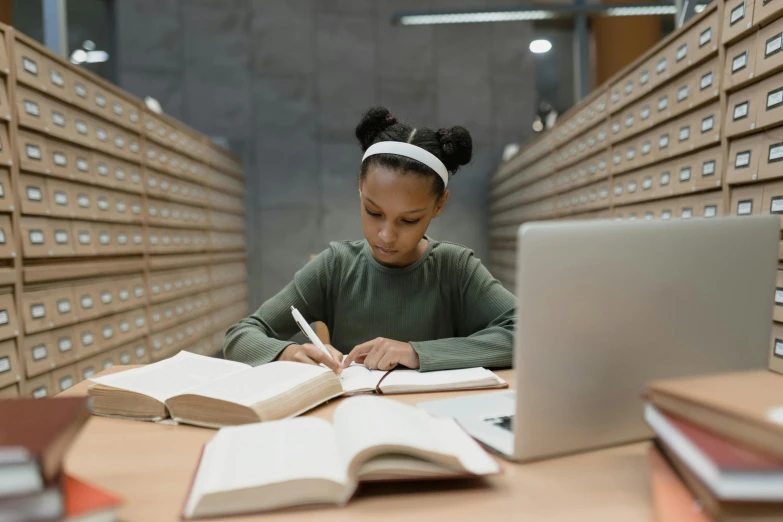 a woman sitting at a table in front of a laptop, pexels contest winner, academic art, infinite library, black teenage girl, sydney hanson, highly upvoted