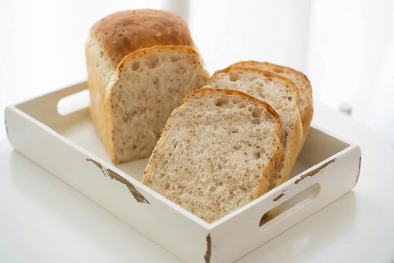 a close up of a loaf of bread in a box, by Yasushi Sugiyama, unsplash, silver，ivory, textured base ; product photos, beige, toast