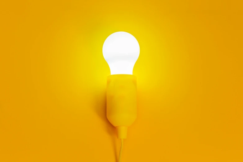 a light bulb sitting on top of a yellow wall, by Évariste Vital Luminais, 5000k white product lighting, colors: yellow, a hyper realistic, soft light - n 9