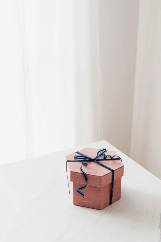 a small pink box sitting on top of a white table, trending on unsplash, giving gifts to people, profile image, navy, 27