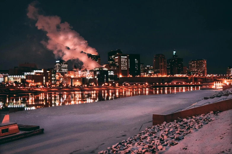 a large body of water with a city in the background, by Greg Rutkowski, pexels contest winner, process art, cold freezing nights, pipe smoke, minneapolis, building along a river
