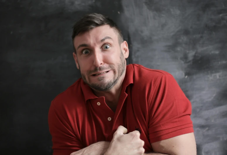 a man in a red shirt posing for a picture, back to school comedy, clayton crain, looking surprised, alessio albi