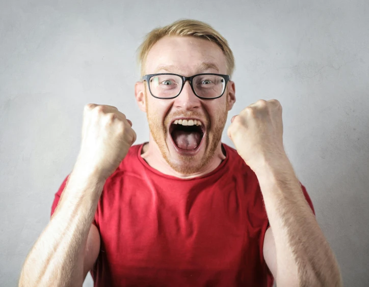 a man in a red shirt and glasses with his fists in the air, pexels contest winner, happening, large gaping mouth, blonde man, celebrate goal, avatar image