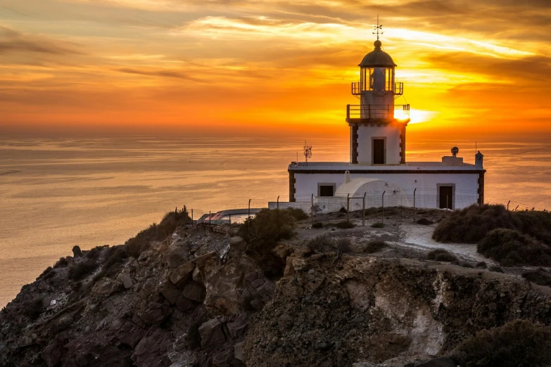 a lighthouse sitting on top of a cliff next to the ocean, by Mathias Kollros, pexels contest winner, golden sunlight, square, greek, spanish