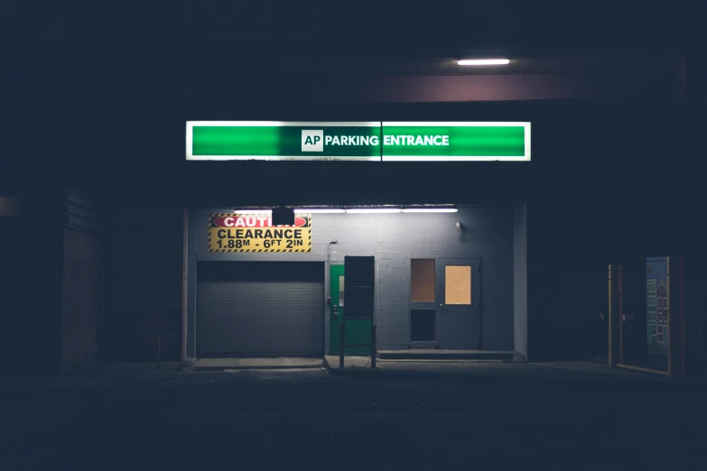 a parking entrance is lit up at night, a photo, inspired by Elsa Bleda, unsplash, a green, emergency room, garage, “hyper realistic