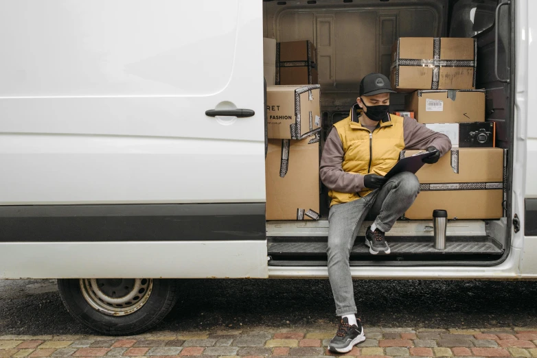 a man sitting in the back of a van reading a book, pexels contest winner, renaissance, delivering packages for amazon, avatar image, worksafe. instagram photo, no - text no - logo