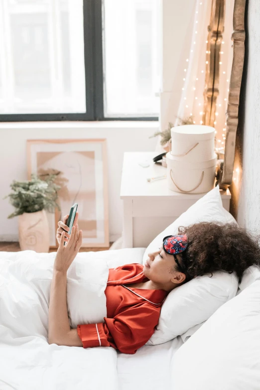 a woman laying on a bed using a cell phone, a cartoon, trending on pexels, oled visor over eyes, inside a cozy apartment, bedhead, digital sunglasses