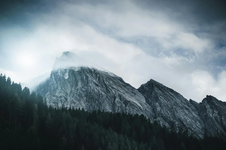 a mountain covered in snow under a cloudy sky, unsplash contest winner, romanticism, dark pine trees, limestone, grey, 4 k hd wallpapear