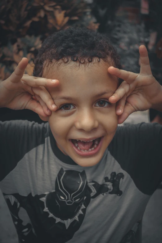 a little boy holding his hands up to his face, a picture, pexels contest winner, buck teeth, grey ears, diverse, smiling down from above