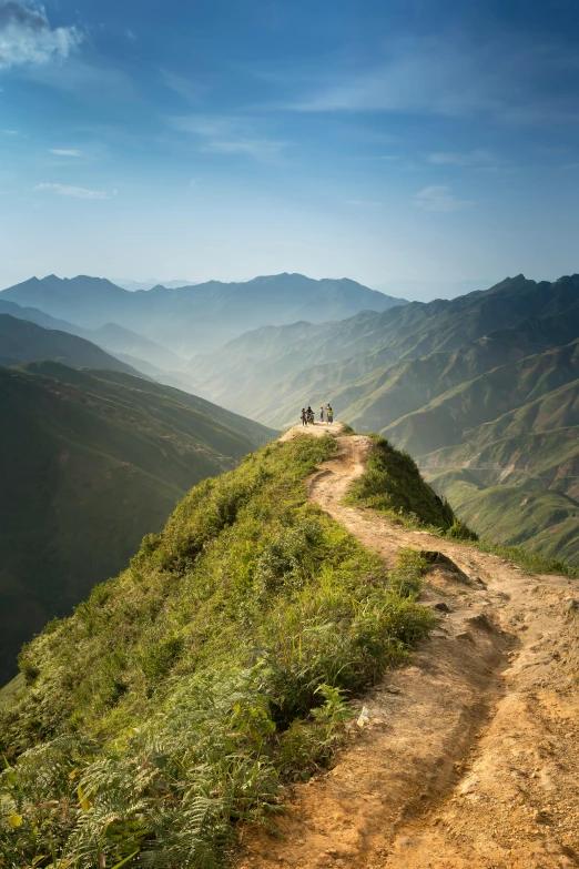 a group of people standing on top of a mountain, by Reuben Tam, narrow footpath, vietnam, sunlit, paths