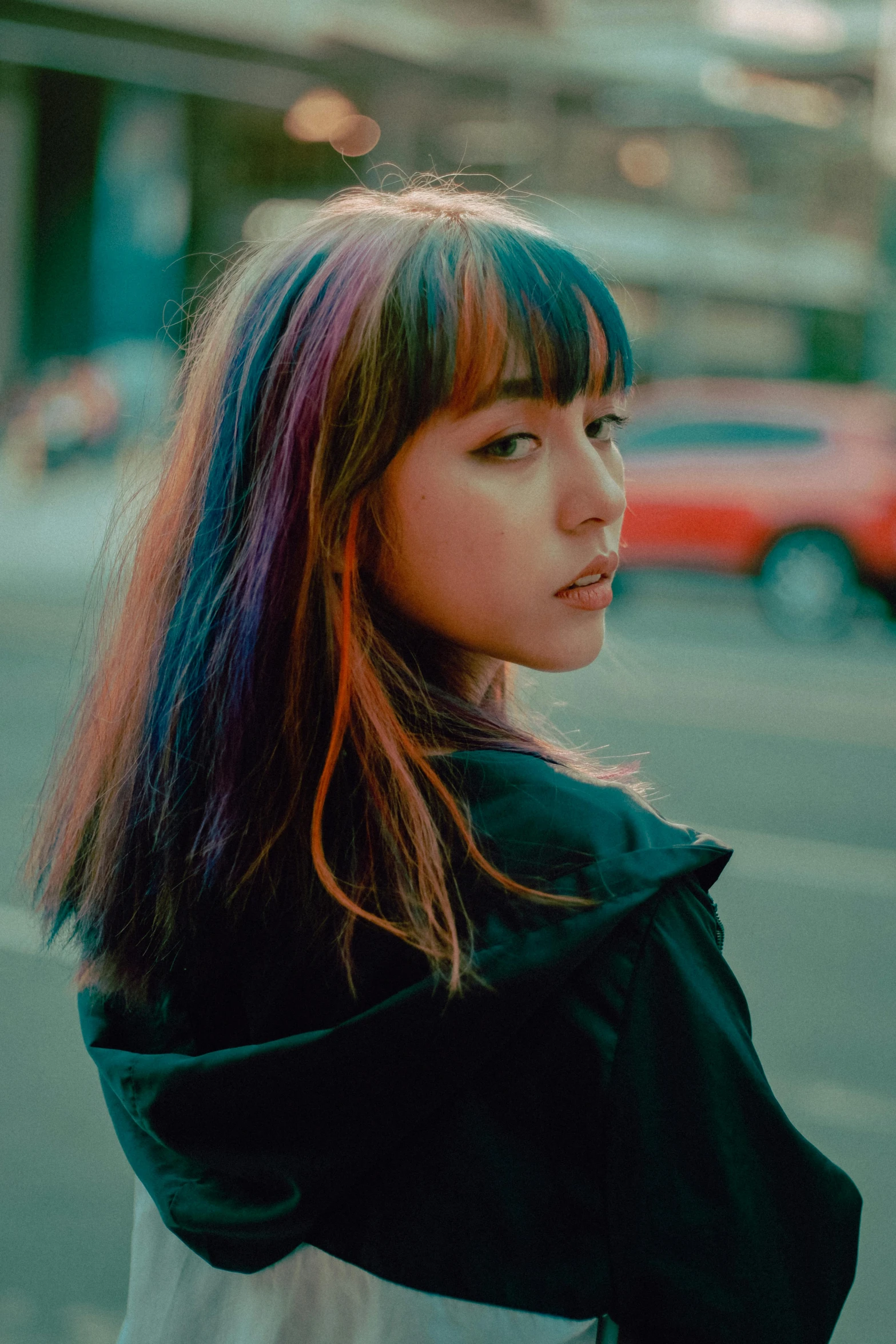 a woman with colorful hair standing on a city street, a colorized photo, inspired by Elsa Bleda, trending on pexels, realism, black bangs, gorgeous young korean woman, chromatic iridescence, asian human