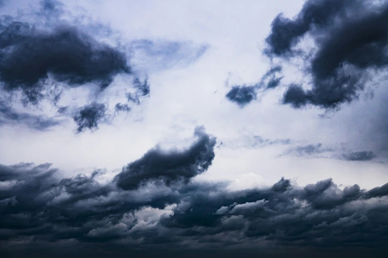 a large body of water under a cloudy sky, an album cover, by Carey Morris, unsplash, romanticism, dark mammatus cloud, shades of blue and grey, bats in sky, low pressure system