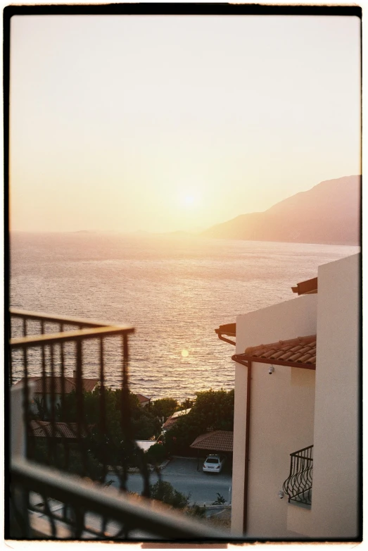 a view of the ocean at sunset from a balcony, a polaroid photo, inspired by Thomas Struth, unsplash, renaissance, capri coast, 1999 photograph, portra, (golden hour)