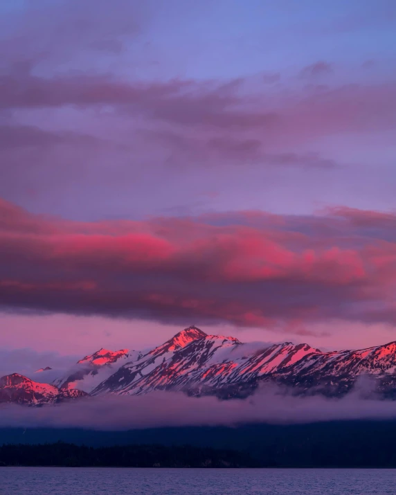 a large body of water with mountains in the background, unsplash contest winner, romanticism, purple and red, snow capped mountains, dusk lighting, multiple stories