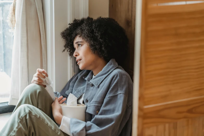 a woman sitting on a window sill holding a cup, trending on pexels, tired expression, ashteroth, profile image, thumbnail