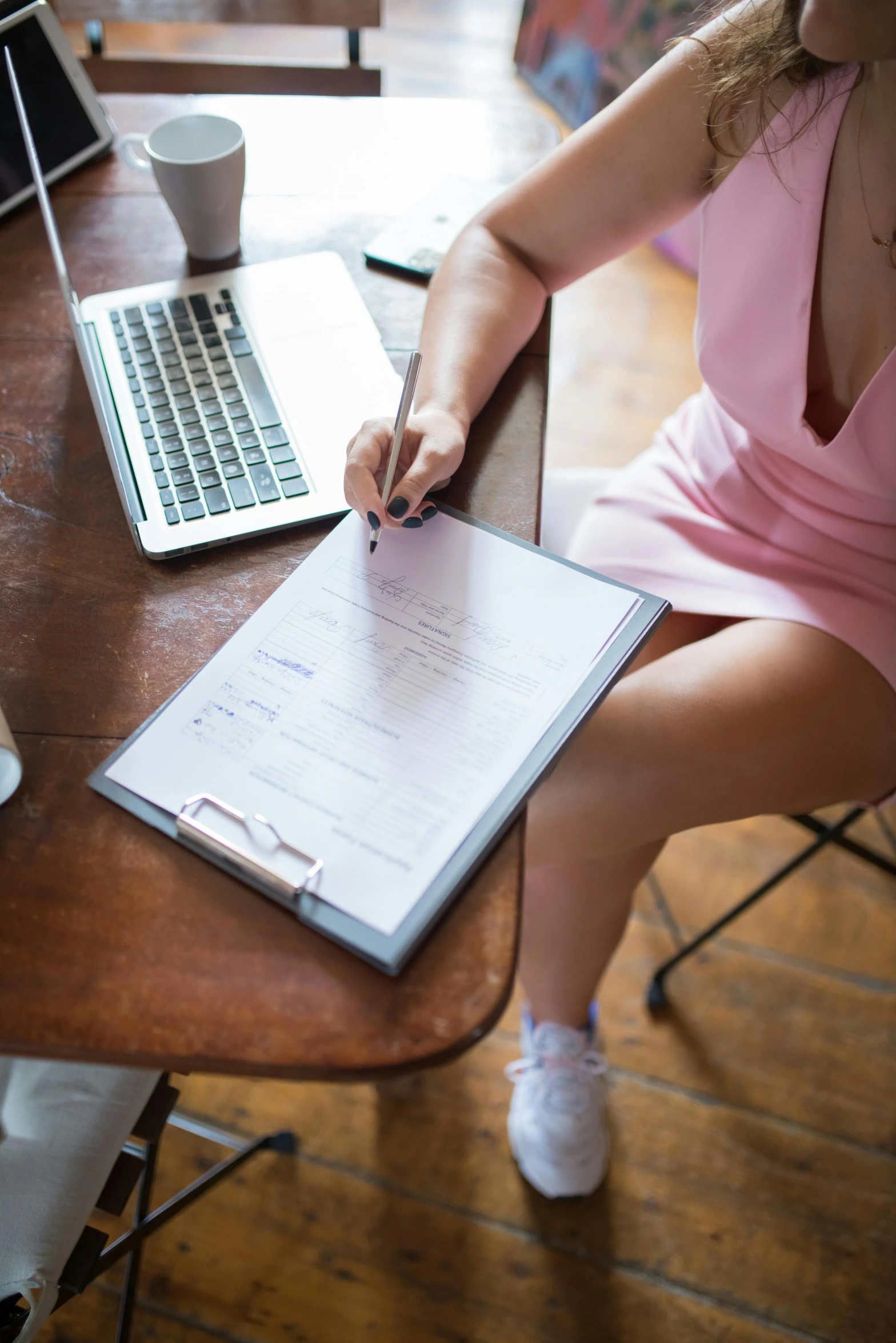 a woman sitting at a table writing on a piece of paper, a cartoon, by Julia Pishtar, pexels, sitting on a mocha-colored table, wearing business casual dress, holding a clipboard, schools