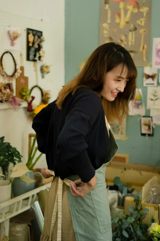 a woman standing in a room holding a purse, inspired by Ni Yuanlu, happening, head bent back in laughter, stillframe, girlboss, in a workshop