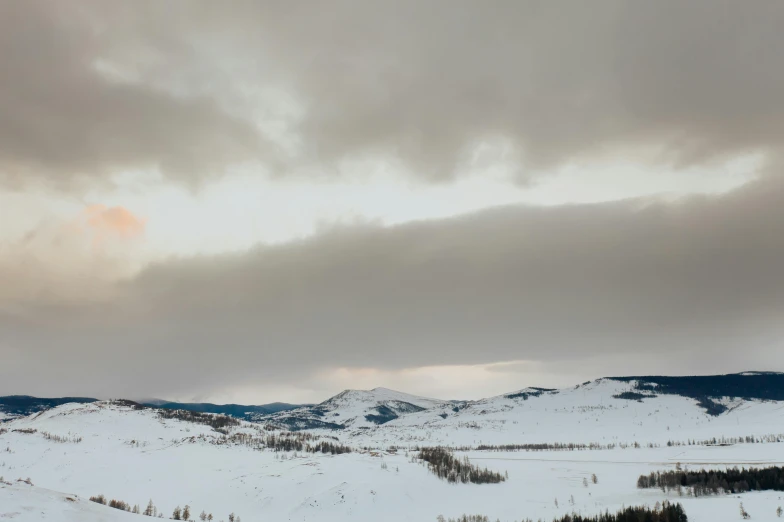 a man riding skis down a snow covered slope, by Emma Andijewska, unsplash contest winner, visual art, cloudy overcast sky, wyoming, silver，ivory, panorama view