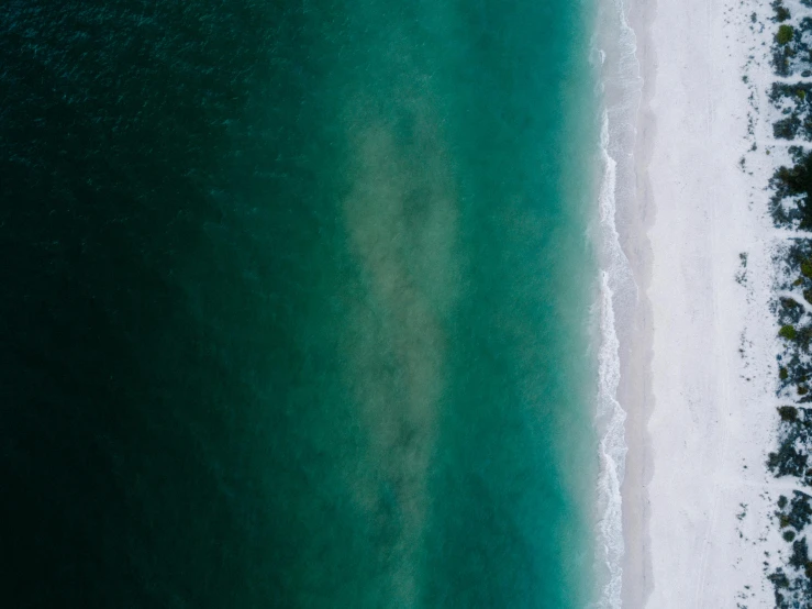 a large body of water next to a beach, by Jacob Toorenvliet, unsplash contest winner, minimalism, white and teal metallic accents, high angle close up shot, dark brown white green colours, 4k —height 1024 —width 1024