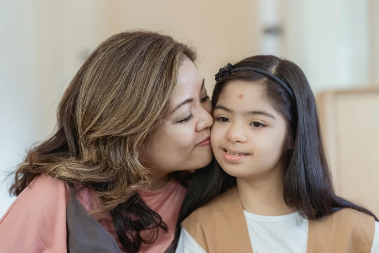 a woman kissing a little girl on the cheek, pexels contest winner, mingei, avatar image, asian descent, woman with braided brown hair, medical image