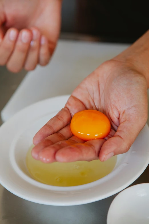 a person holding an egg on a plate