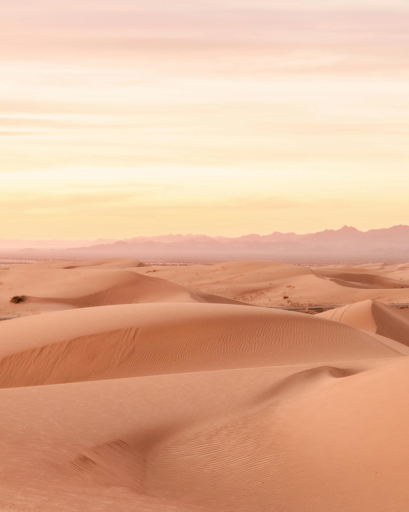 a person riding a horse in the desert, in shades of peach, majestic dunes, /r/earthporn, background image