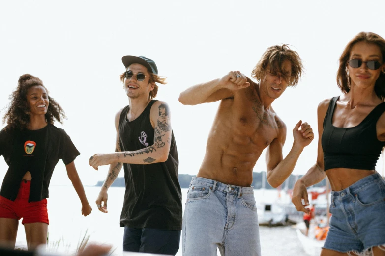 a group of people standing next to each other on a beach, by Christen Dalsgaard, trending on pexels, happening, skateboarder style, belly button showing, jamie campbell bower, on a boat