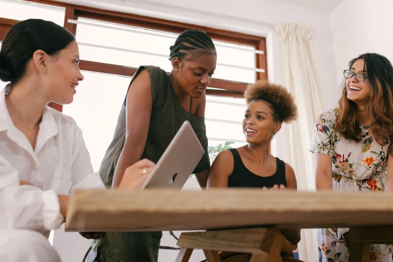 a group of women standing around a wooden table, trending on pexels, happening, afro tech, standing on a desk, profile image, no duplicate image