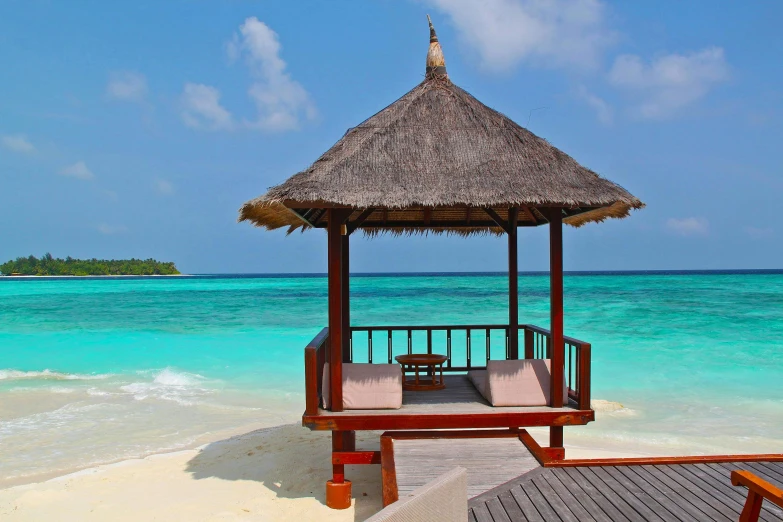 a gazebo sitting on top of a sandy beach next to the ocean, pexels contest winner, hurufiyya, maldives in background, square, luxurious wooden cottage, brown and cyan color scheme