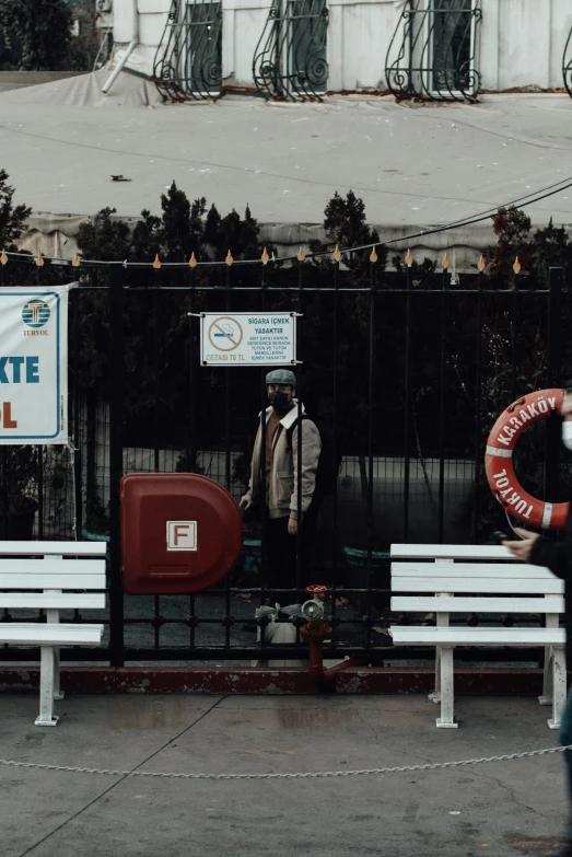 a man walking past a white bench with a life preserver on it, a poster, by Elsa Bleda, pexels contest winner, street signs, boat, aykut aydogdu, full faced
