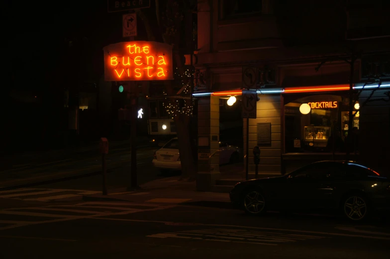 a neon sign on the side of a building, by Elsa Bleda, unsplash, dimly-lit cozy tavern, photograph of san francisco, jenny seville, vista view