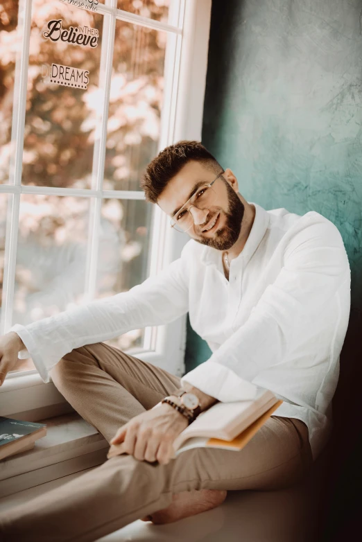 a man sitting on a window sill next to a laptop, an album cover, inspired by Ismail Acar, pexels contest winner, renaissance, elegant smiling pose, wearing white clothes, фото девушка курит, cute slightly nerdy smile